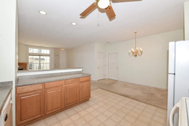 kitchen featuring ceiling fan with notable chandelier, freestanding refrigerator, recessed lighting, a peninsula, and light floors