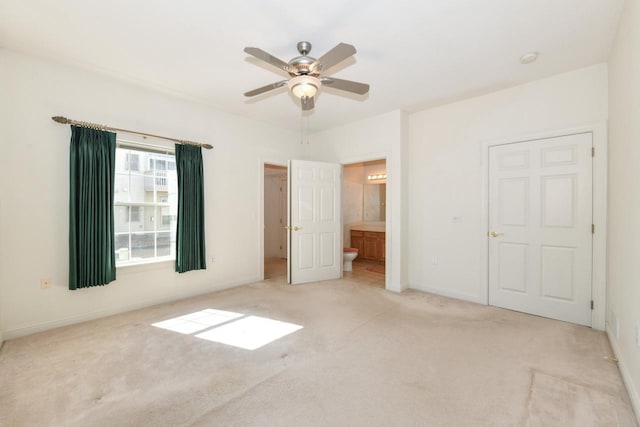 unfurnished bedroom with a ceiling fan, baseboards, carpet floors, and connected bathroom