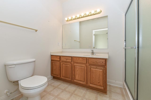 bathroom featuring tile patterned floors, toilet, a shower with door, baseboards, and vanity