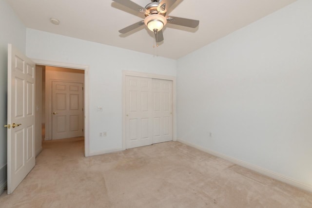 unfurnished bedroom with a ceiling fan, light colored carpet, a closet, and baseboards