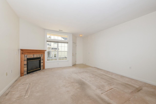 unfurnished living room featuring a brick fireplace, light colored carpet, and baseboards