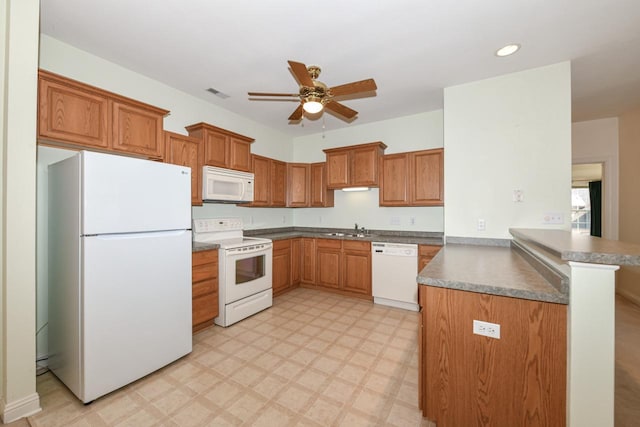 kitchen featuring light floors, a peninsula, white appliances, a ceiling fan, and a sink