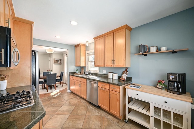 kitchen featuring light brown cabinets, a sink, dark countertops, recessed lighting, and appliances with stainless steel finishes