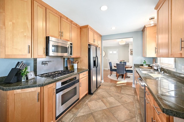 kitchen with a sink, tile countertops, plenty of natural light, and stainless steel appliances