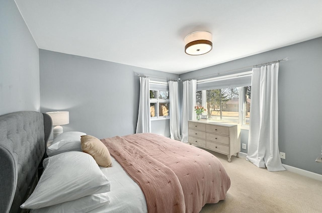 bedroom with baseboards and light carpet