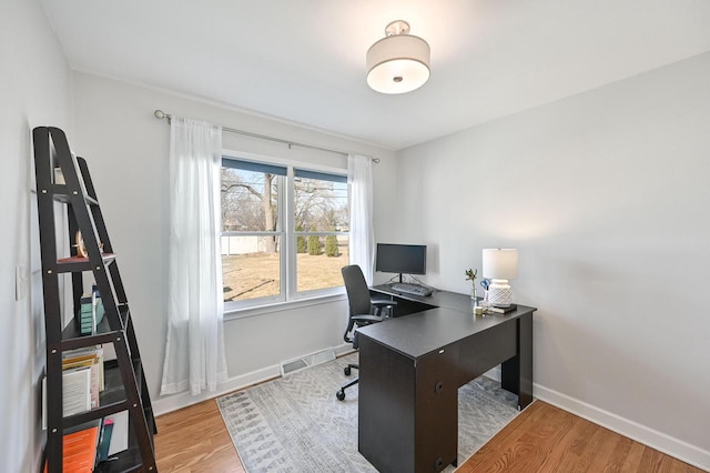 home office featuring visible vents, baseboards, and wood finished floors