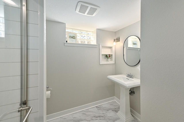 bathroom featuring visible vents, marble finish floor, walk in shower, and baseboards