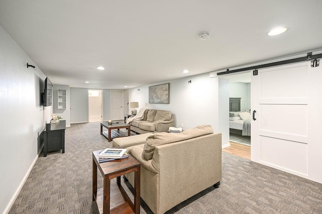 carpeted living room featuring recessed lighting, a barn door, and baseboards