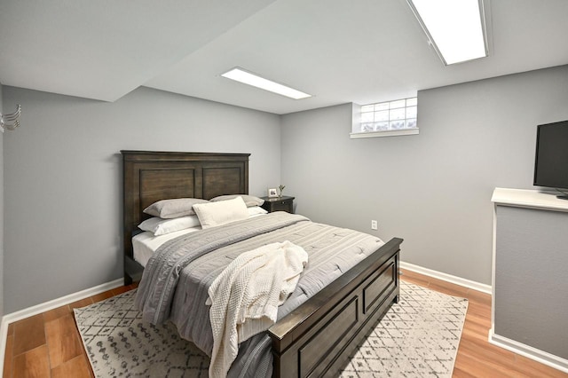 bedroom with baseboards and light wood finished floors