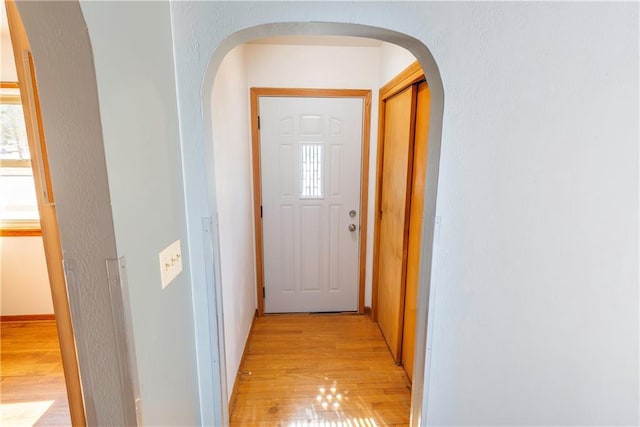 doorway featuring light wood-type flooring and arched walkways