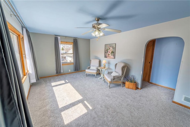 living area featuring baseboards, carpet floors, and ceiling fan