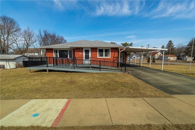 view of front of house featuring an attached carport, driveway, a front lawn, and fence