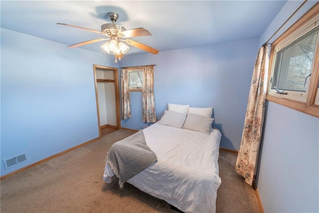 carpeted bedroom featuring visible vents, baseboards, a closet, and ceiling fan