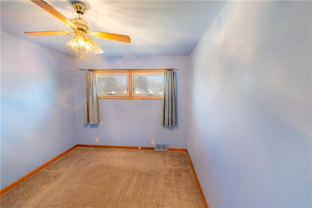 unfurnished room with carpet, baseboards, visible vents, and ceiling fan