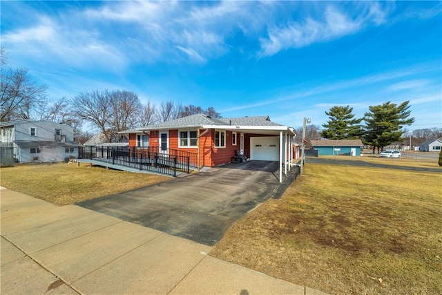 view of front of property featuring a front yard, fence, a garage, and aphalt driveway