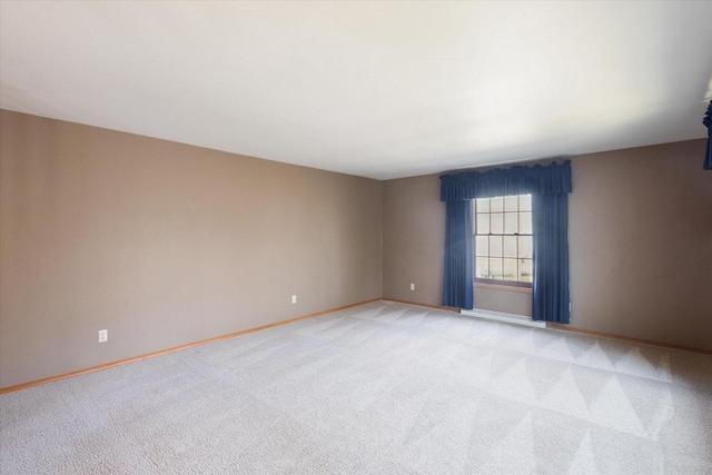 unfurnished room with light carpet and baseboards