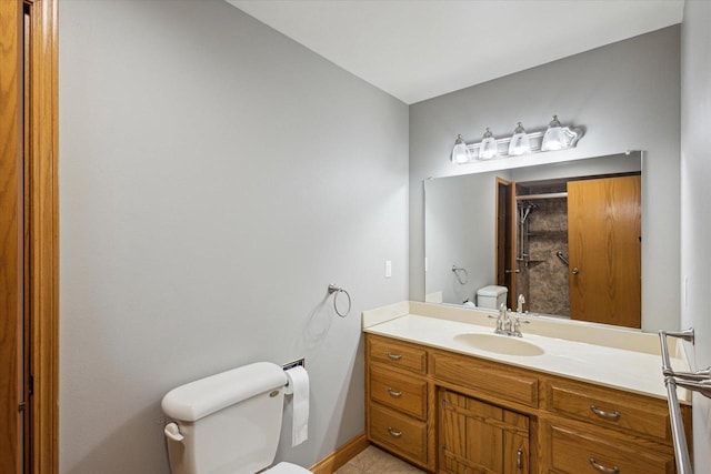 full bath featuring vanity, toilet, baseboards, and a stall shower