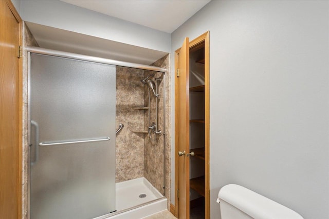 full bath featuring a shower stall and toilet