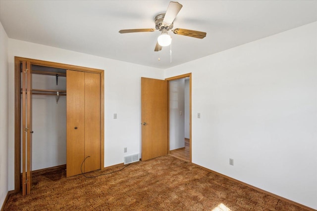 unfurnished bedroom featuring a closet, visible vents, ceiling fan, and carpet