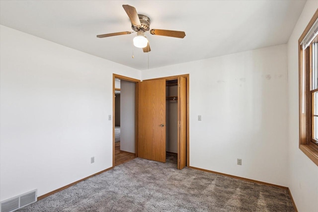 unfurnished bedroom featuring a ceiling fan, carpet, visible vents, baseboards, and a closet