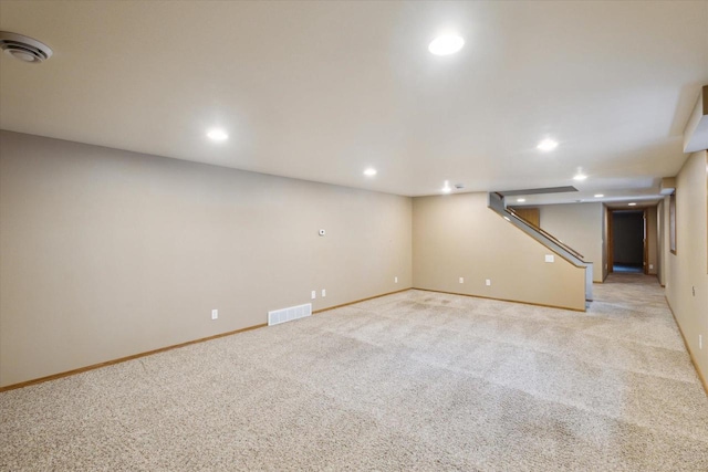 finished below grade area featuring light colored carpet, recessed lighting, visible vents, and baseboards