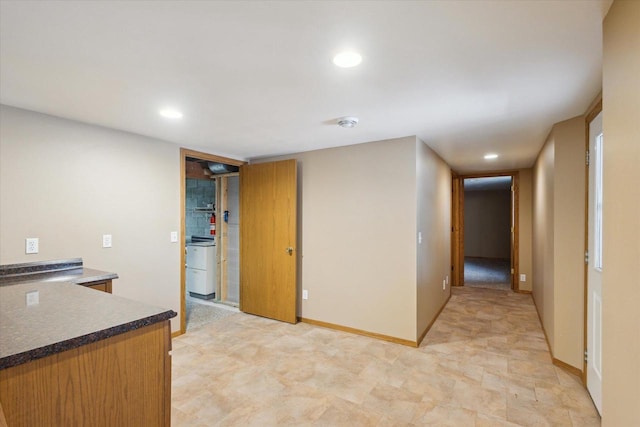 kitchen featuring dark countertops, recessed lighting, and baseboards