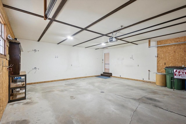 garage with a garage door opener and baseboards