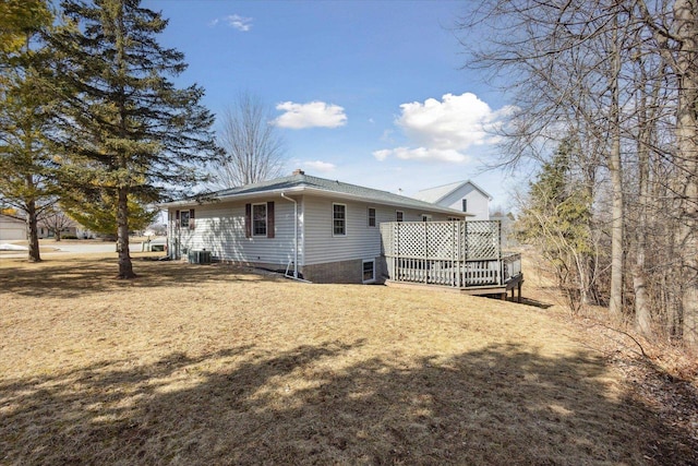 exterior space featuring a lawn, cooling unit, and a wooden deck