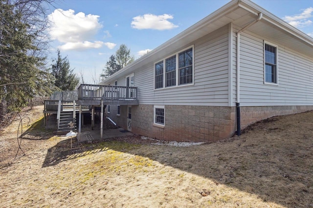 view of home's exterior with stairs and a deck