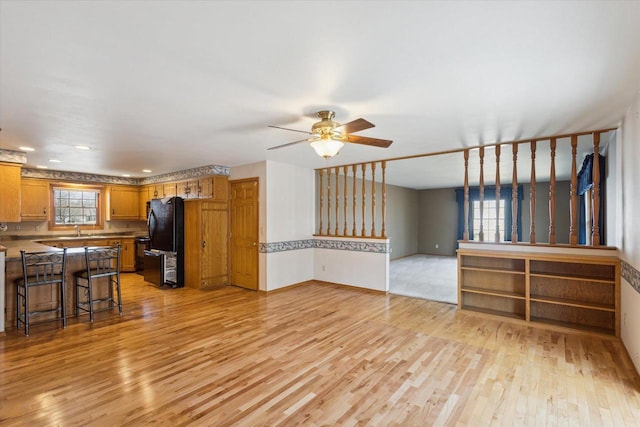 living room featuring a healthy amount of sunlight, light wood-style floors, and a ceiling fan