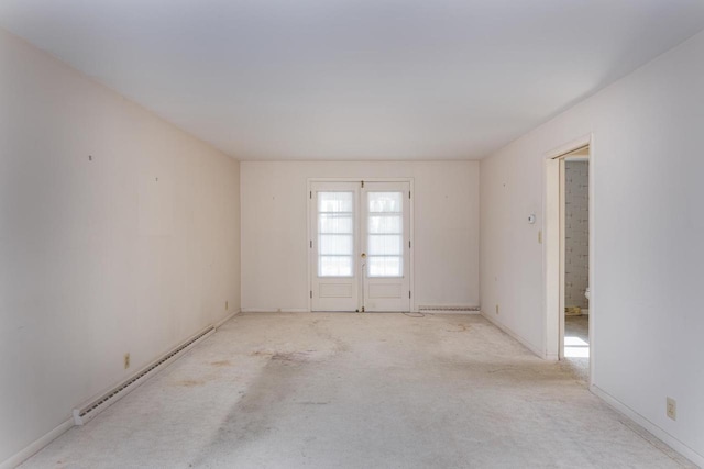 unfurnished room featuring baseboard heating, french doors, and carpet