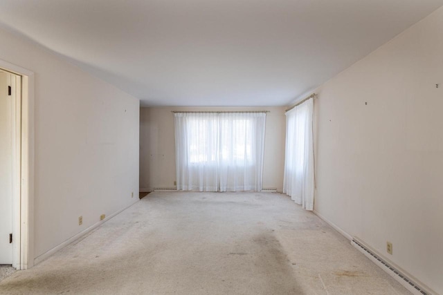 carpeted empty room with a baseboard radiator