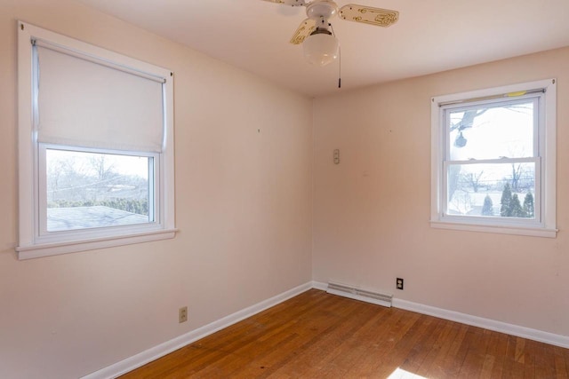 empty room with a ceiling fan, wood finished floors, baseboards, and visible vents