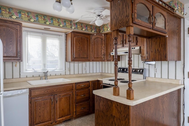 kitchen with white appliances, wallpapered walls, ceiling fan, a sink, and under cabinet range hood