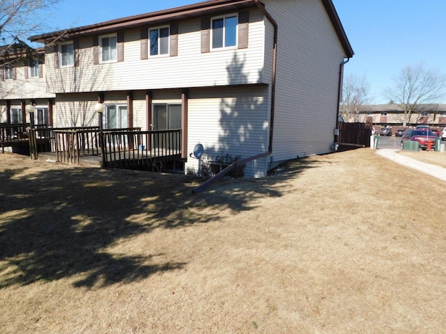 rear view of house with a wooden deck and a yard