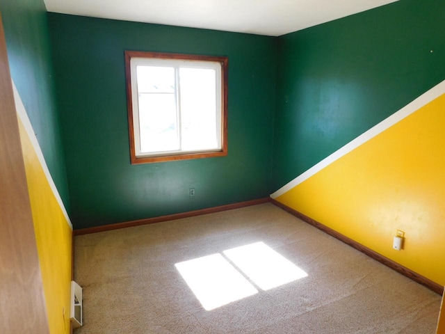 carpeted empty room featuring baseboards