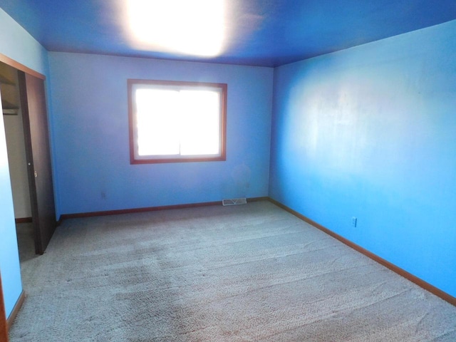 unfurnished bedroom with a closet, visible vents, baseboards, and carpet floors