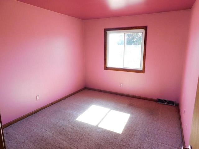 carpeted empty room featuring visible vents and baseboards