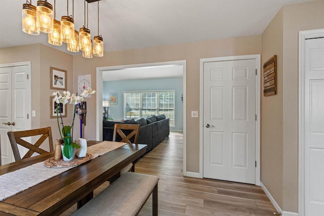 dining space with a chandelier, baseboards, and wood finished floors