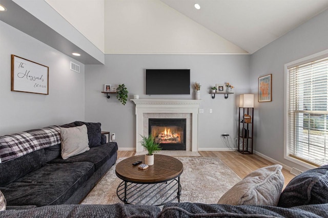 living area featuring visible vents, wood finished floors, recessed lighting, baseboards, and a tile fireplace