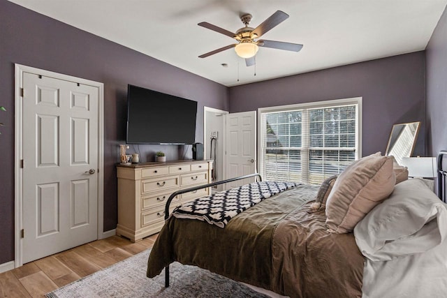 bedroom with baseboards, light wood-type flooring, and ceiling fan