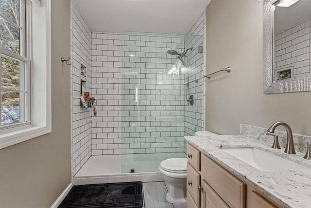 bathroom featuring baseboards, toilet, a stall shower, and vanity