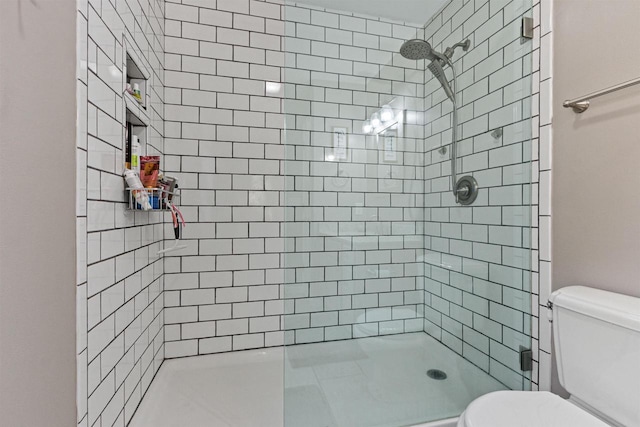 bathroom with toilet and tiled shower