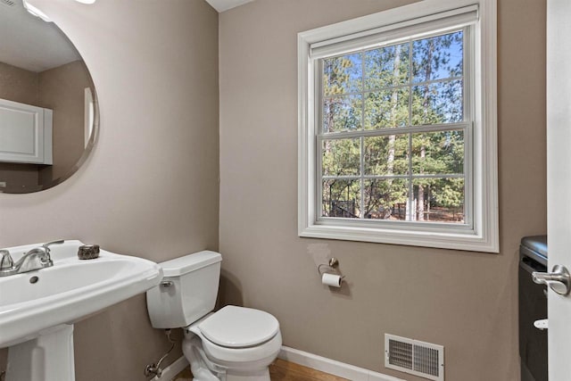 bathroom featuring a sink, visible vents, baseboards, and toilet