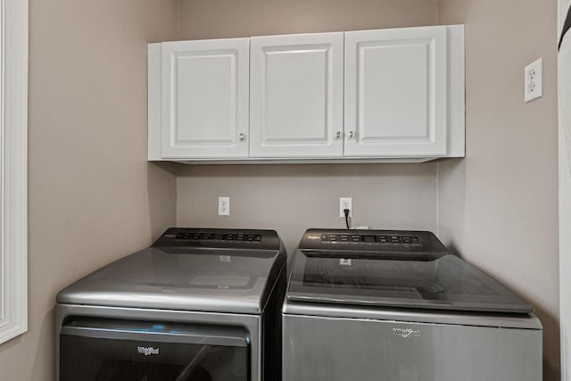 clothes washing area with cabinet space and independent washer and dryer