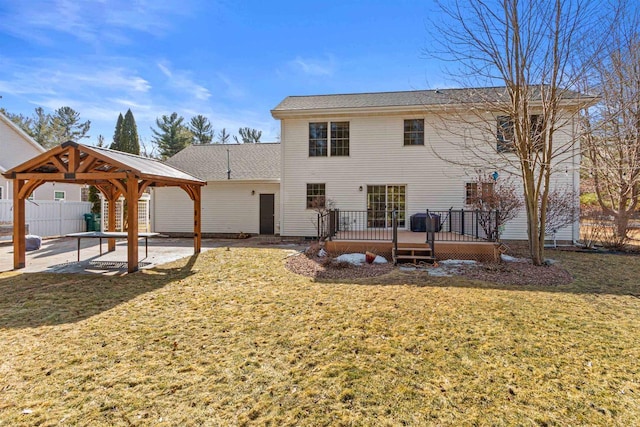 rear view of house with a lawn, a deck, a patio, fence, and a gazebo