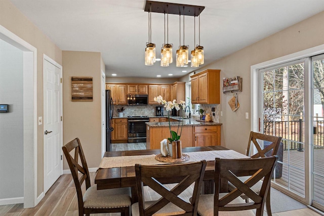 dining room with an inviting chandelier, light wood-style flooring, recessed lighting, and baseboards