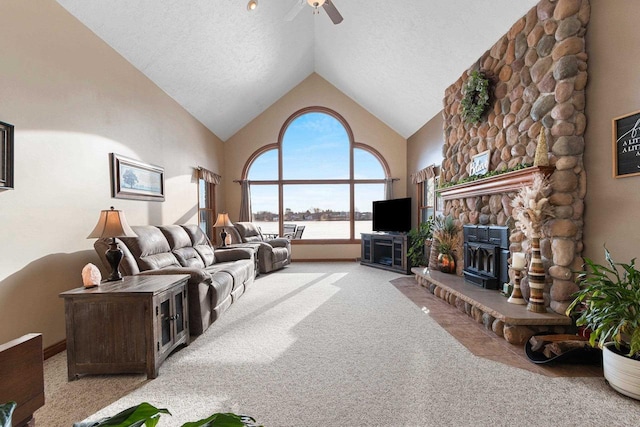 carpeted living room with a stone fireplace, a textured ceiling, high vaulted ceiling, and ceiling fan