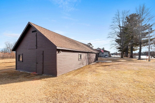 view of property exterior with an outdoor structure, a lawn, and a barn