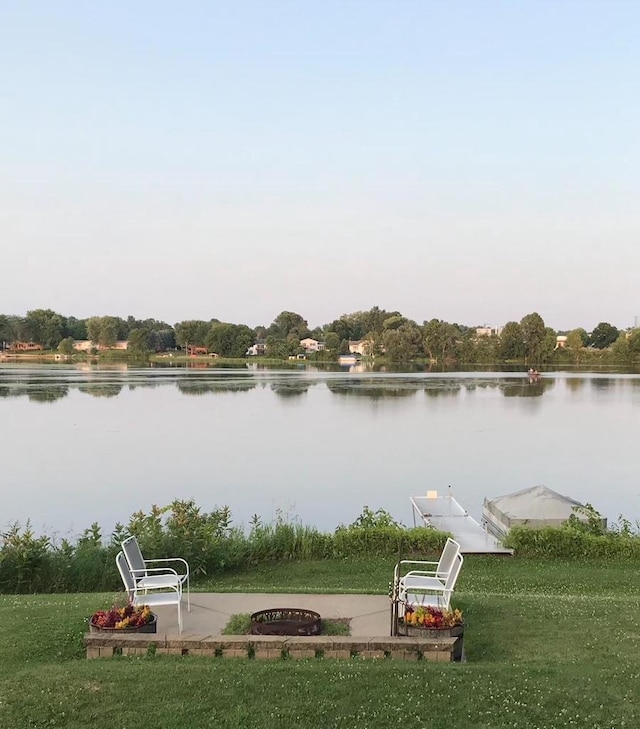 water view with a fire pit and a dock